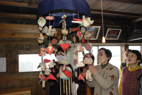 修復された傘福を見上げて感嘆の声を上げる地元の女性たち