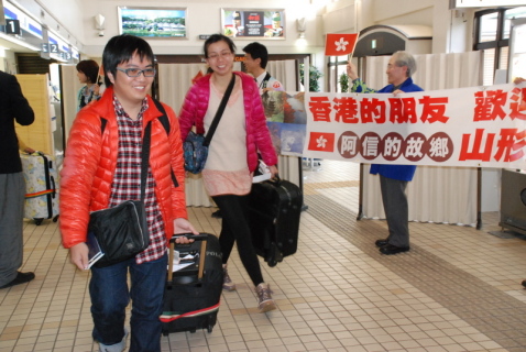 香港から初のインバウンドチャーター機で到着したツアー客を横断幕を掲げて歓迎した＝1日午後2時50分、庄内空港