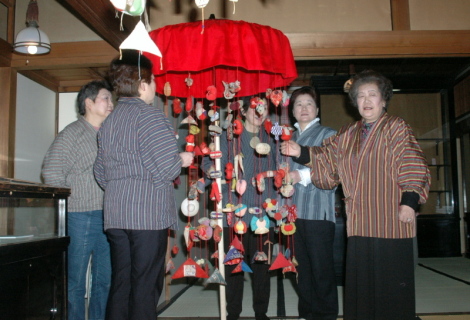 関会長（右）ら女性会員が修復した傘福を再展示