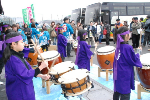 上田太鼓連中の子供たちが勇ましい演奏でバスから降り立った観光客を歓迎した＝酒田夢の倶楽