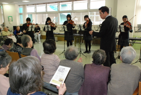 酒田中央高音楽部の演奏に合わせてお年寄りたちが唱歌などを歌った