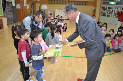 難波会長（右）が園児たちに交通安全をテーマにした紙芝居を贈った＝常念寺保育園