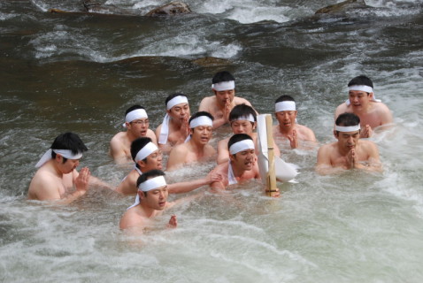 雪解けの冷たい水が流れる川で一心に「大祓詞」を唱える参加者たち