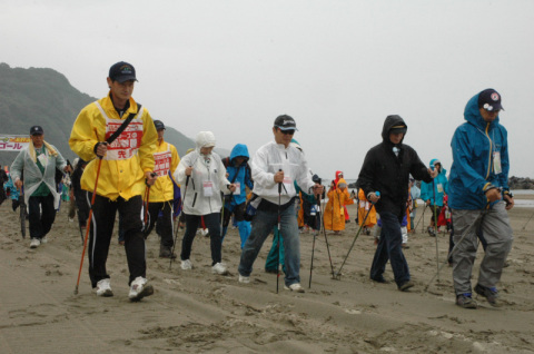 湯野浜海岸でノルディックウオークに取り組む参加者たち＝9日