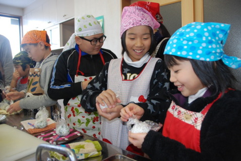 炊きたてのご飯に大根葉を交ぜ、菜飯のおにぎりを作る児童たち