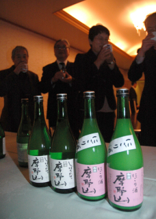 温海地域オリジナルの日本酒「摩耶山」の発表会で試飲する出席者たち