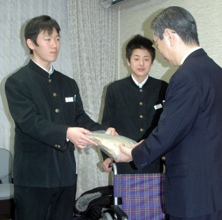 本間市長（右）に義援金を手渡す土門会長（左）。中央は佐藤前会長