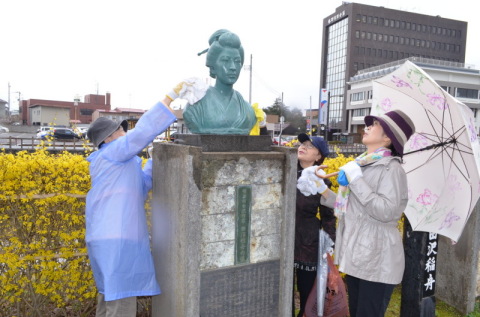 田沢稲舟の像を清掃する観光ボランティアガイドのメンバーたち
