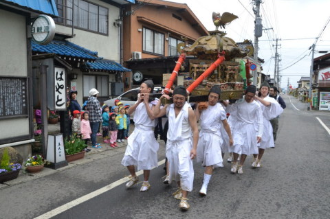 みこしを担ぎ威勢の良い掛け声を上げながら、湯田川地区内を練り歩く若者たち