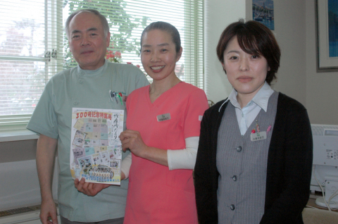 節目の「診療所だより」300号を持つ（左から）矢島所長、伊藤さん、大島さん