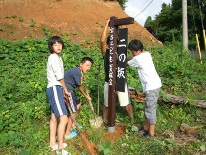 宝谷坂の歴史を伝える看板を設置する子供たち