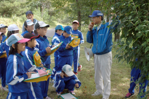 五十嵐さん（右）の解説で樹木について学ぶ児童たち
