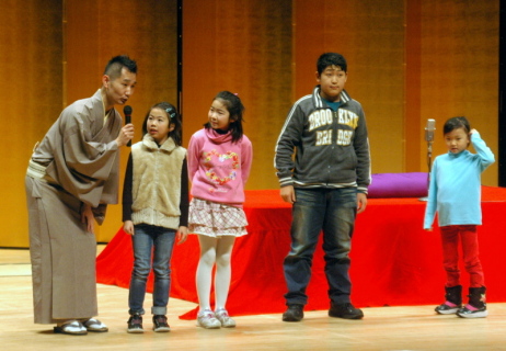 柳朝さん（左）の指導で小噺を披露する児童たち