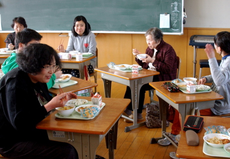 6年生と共に給食に舌鼓を打つ平津野菜グループのメンバーたち