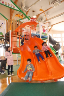 「遊びの広場」に設置された大型遊具を園児たちが歓声を上げながら滑り降りた