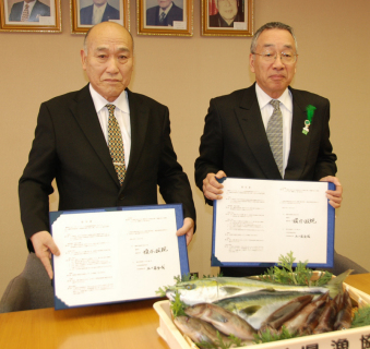五十嵐組合長（左）、榎本市長が学校給食への地場水産物導入に関する協定の調印を行った