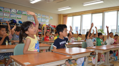 先生の問い掛けに「はーい」と元気良く手を挙げて答える子どもたち＝25日、朝四小
