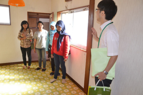 空き家を活用したシェアハウスで、入居の説明を受けるインドネシアからの留学生たち＝16日