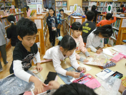 図書館で本を借りる児童たち