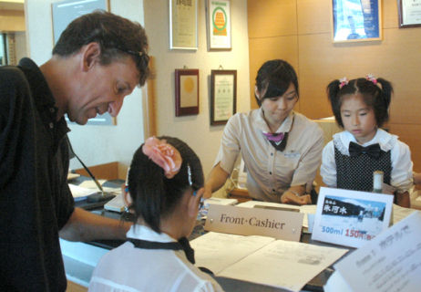 ウイリアムさん（左）やスタッフの指導でホテル業務を体験する子供たち