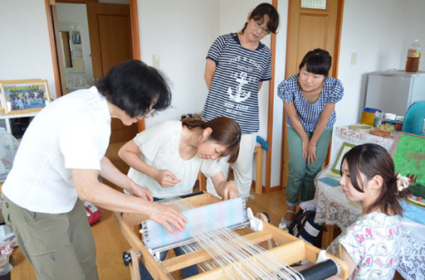 中村さん（左）の指導で機織り体験をする保育士たち