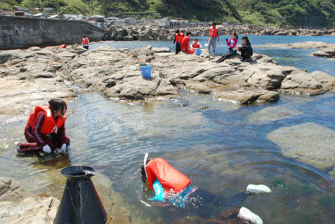 加茂水族館裏の岩場で、小魚やヒトデなどの生物を採取する山形大理学部生物学科の学生たち