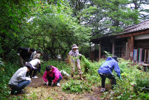 今井氏のアトリエ周辺で草刈りや敷設されたれんがの汚れなどを取り除くボランティアたち