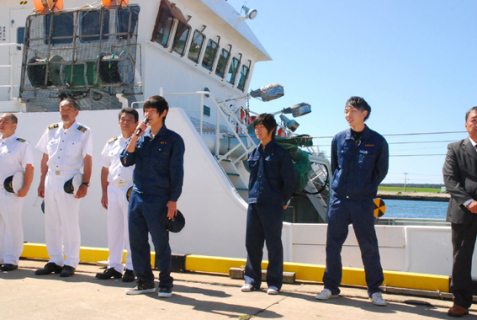 乗船する鳥海丸（奥）の前で実習生（作業服の3人）が一人一人あいさつした出港式