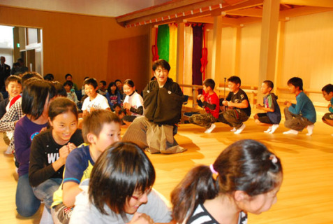 野村万禄さん（中央）の指導で狂言の表現などを習う子供たち＝松山城址館
