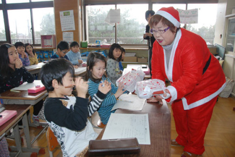 サンタクロースに扮（ふん）した渡前分会のメンバーが児童にプレゼントを手渡した