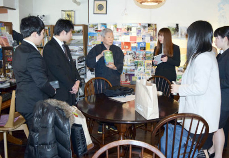 外国人に人気の旅館を経営する澤さん（中央）に話を聴く学生たち＝17日午後、澤の屋