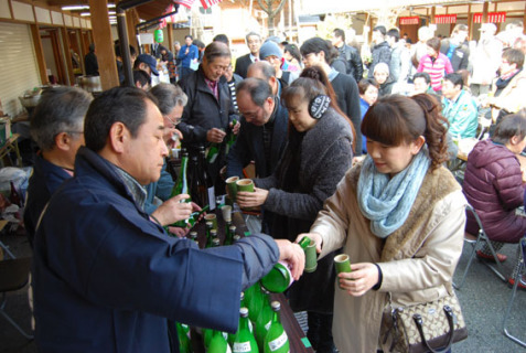 専用の竹コップに「摩耶山」の濁り酒や搾りたて原酒をついでもらう人たち
