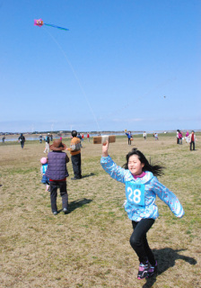 春本番の陽気の中、凧揚げを楽しむ参加者たち