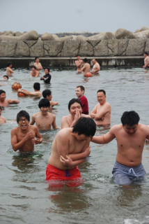 伝統の「水開き」が行われ、生徒たちがまだ冷たい海に入り気合を示した