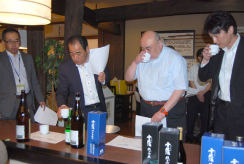 月山8合目で越冬貯蔵した今年の「雪醸酒」の味わいを確かめる参加者たち