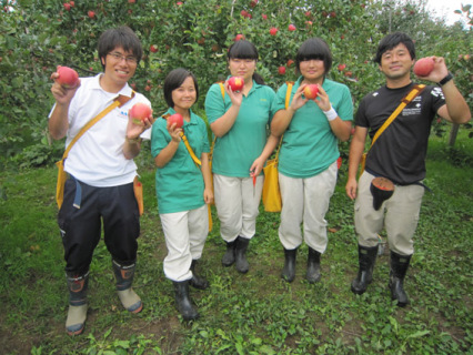 開港25周年記念でプレゼントする特別リンゴを手に笑顔の庄内農業高の生徒ら