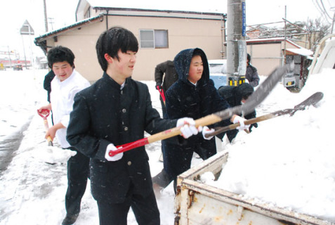 学校周辺の道路で除雪を行う天真学園高の生徒たち