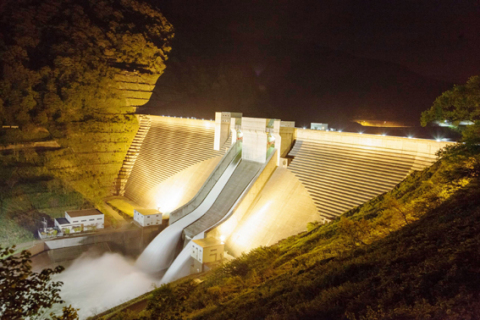 巨大な月山ダムの堤体と自然放流のライトアップ＝昨年5月