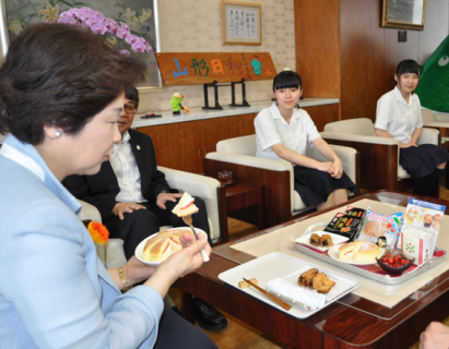 鶴中央高の3年生が県庁を訪問し、吉村知事（左手前）に新商品をＰＲ