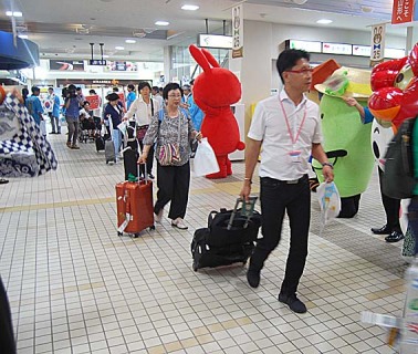 韓国・アシアナ空港のチャーター便が庄内空港に到着。ロビーで歓迎の気持ちを伝えた＝21日