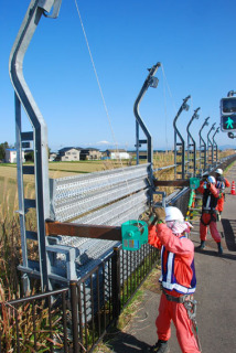 冬に向けて防雪柵の設置作業が始まった＝13日午前、鶴岡市矢馳