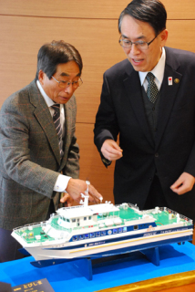 酒田市役所で「とびしま」の模型を前に談笑する塚田さん（左）と丸山市長