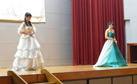 ステージで鶴岡シルクのドレスを披露する生徒たち