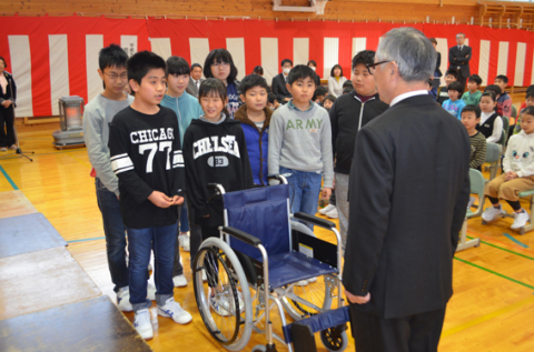 スポーツ・ボランティア委員会の児童たちが菅井社長に車椅子を贈った