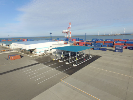 供用が始まった酒田港国際ターミナルのトラックゲート（中央の青い屋根）と管理棟（その奥の棟）＝写真提供・県港湾事務所