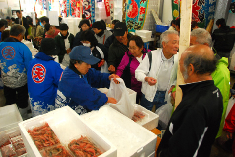 大勢の人が訪れ、格安で販売される鮮魚を買い求めた