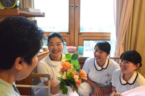学生と看護師が花籠を手に患者を訪問。「きれいだの」と笑顔を見せた