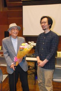 上映後に会場内で、来場者から贈られた花束を手に記念撮影した井山さん（左）と渡辺監督