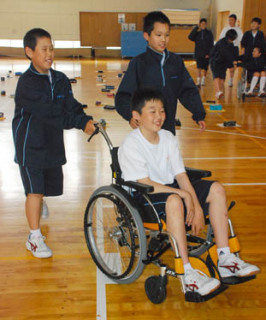 車椅子の介助を体験する鳥海八幡中の1年生たち
