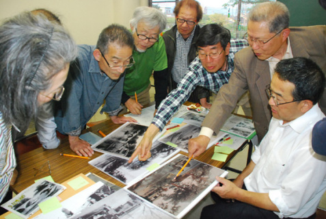 新井田川周辺の古写真について語り合う参加者たち。右手前は小野寺会長